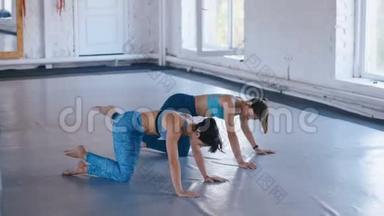 两个女运动员在<strong>健身</strong>馆锻炼腹部。女运动员正在练习普拉提以<strong>增</strong>强<strong>肌</strong>肉